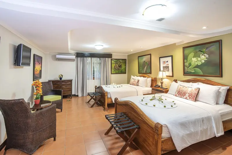 Une chambre lumineuse avec deux lits et un coin salon.