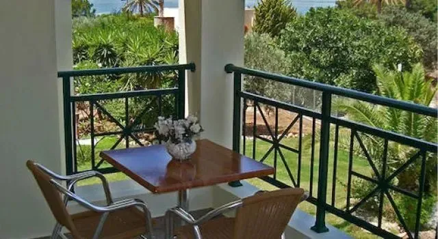 Une terrasse avec une table et des chaises en osier offre une vue sur la végétation luxuriante.
