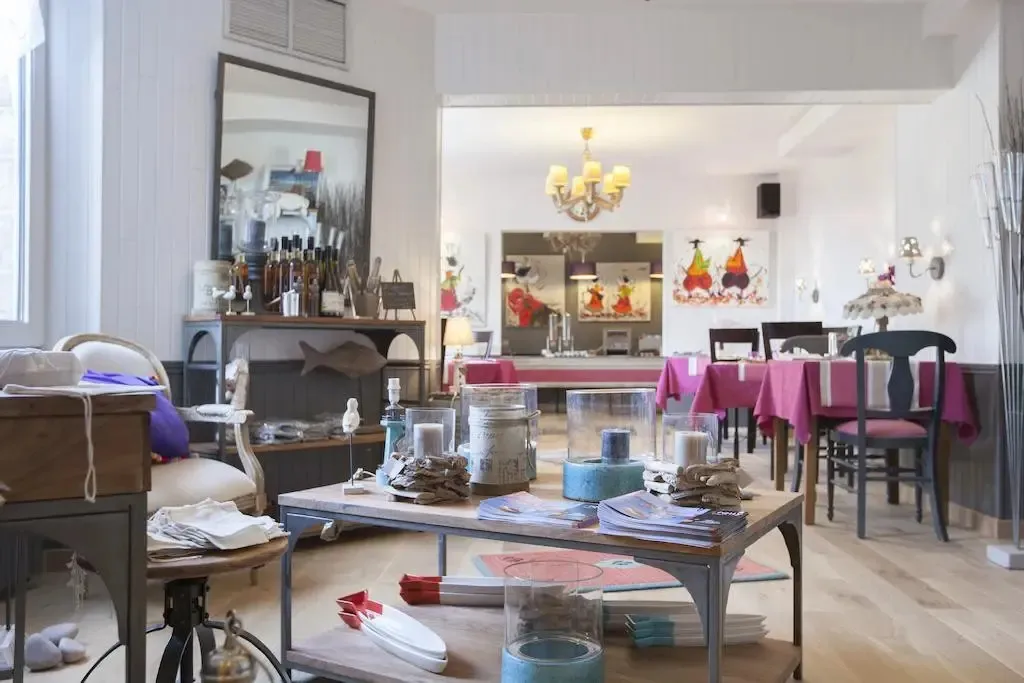 Une salle lumineuse avec des tables dressées et un comptoir de boissons en fond.
