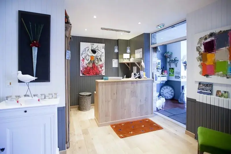 Un comptoir d'accueil lumineux avec des éléments décoratifs et une porte ouverte sur un espace extérieur.
