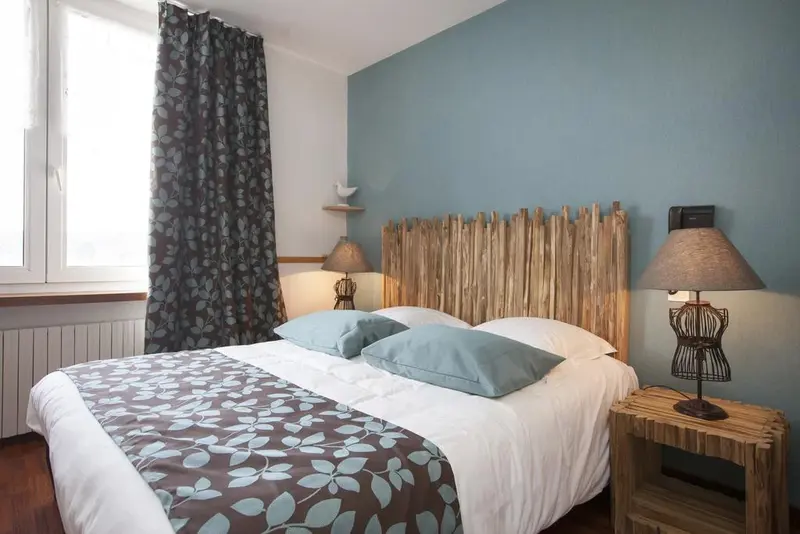Une chambre lumineuse avec un lit double et une décoration soignée.