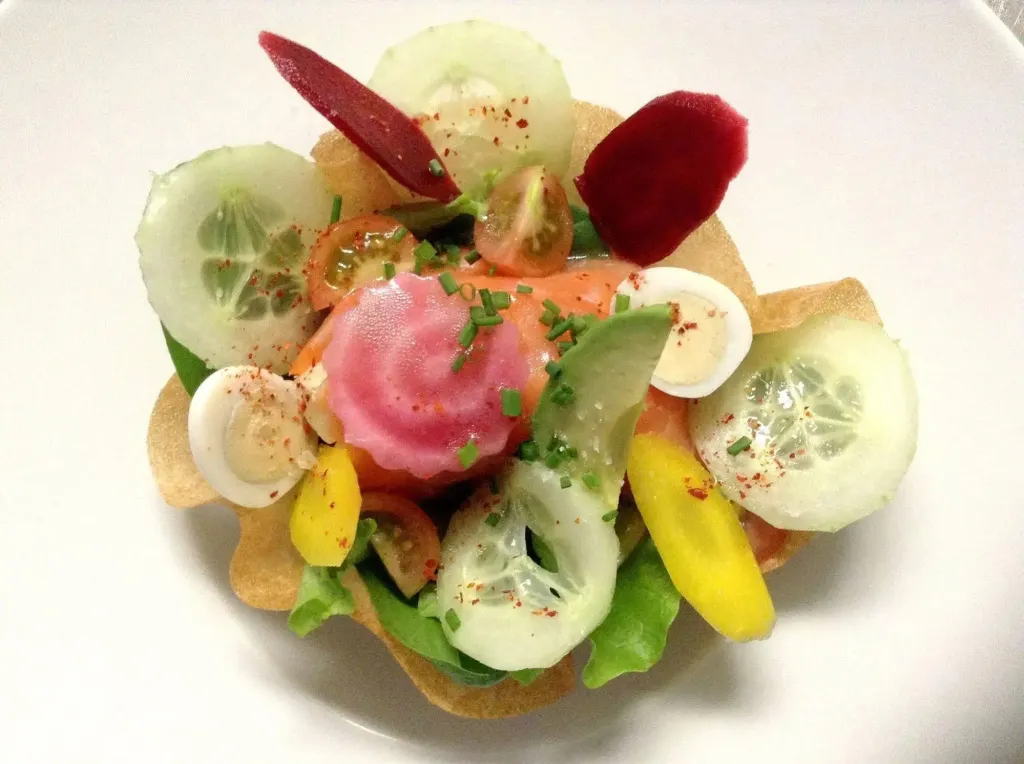 Assiette colorée composée de légumes frais et de saumon.