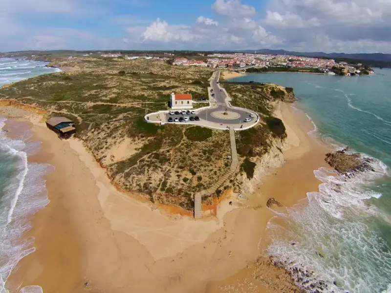 Vue aérienne d'une presqu'île rocheuse bordée de plages et d'une route côtière.