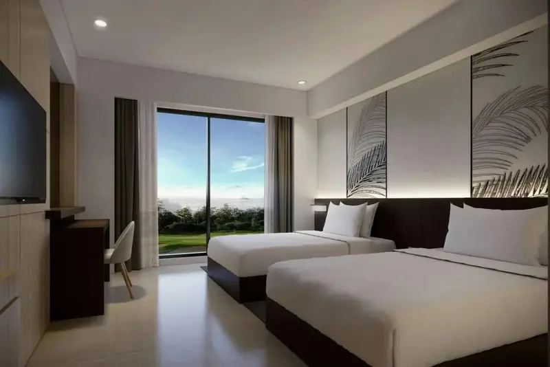 Chambre lumineuse avec deux lits simples et vue sur un paysage verdoyant.
