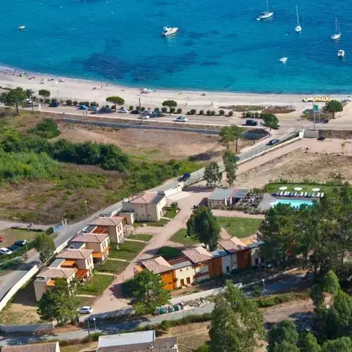 Vue aérienne d'un complexe hôtelier avec piscine et accès à la plage.