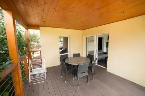 Terrasse couverte avec table et chaises donnant sur un espace intérieur.