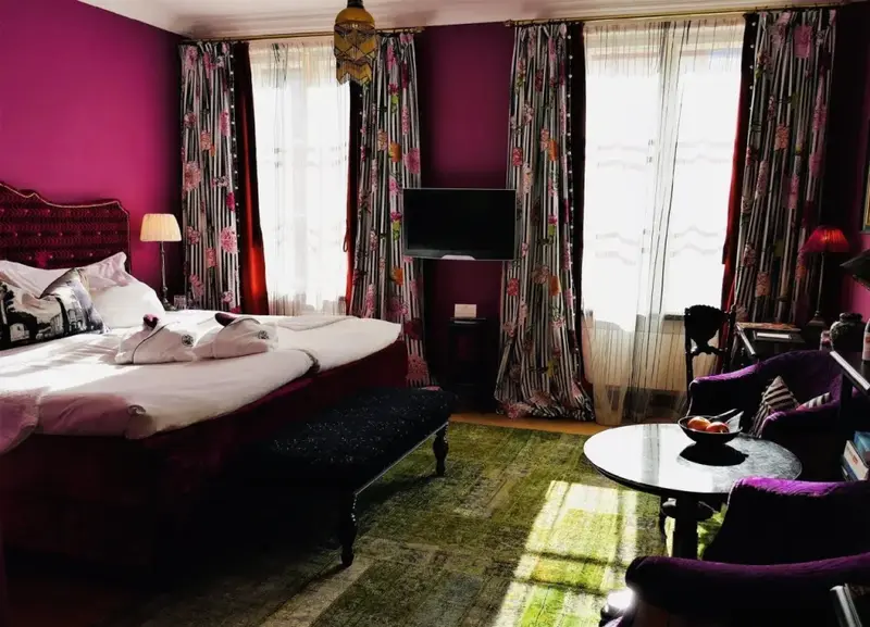 Une chambre lumineuse avec un grand lit et des fauteuils.