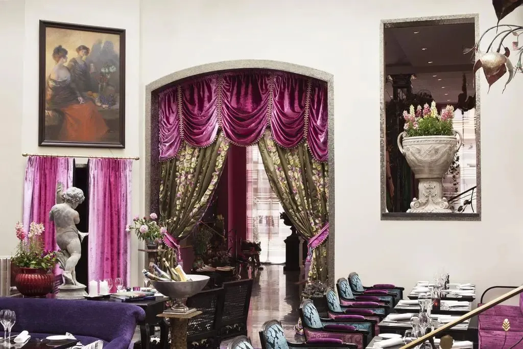 Une salle à manger élégante avec des tables dressées et un décor opulent.