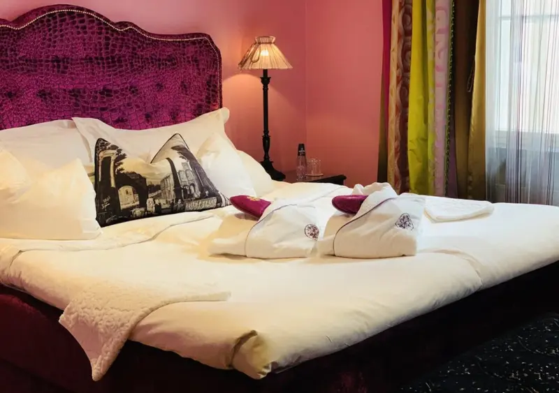Un lit recouvert de draps blancs et d'oreillers dans une chambre décorée.