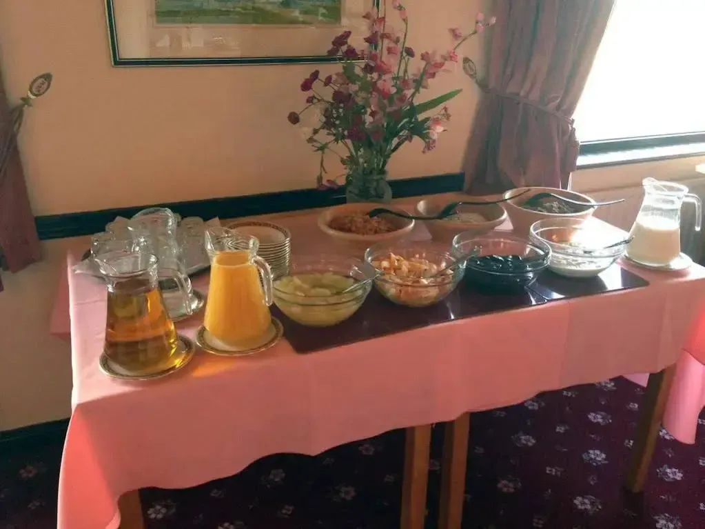 Une table garnie de boissons, de céréales et de fruits frais.