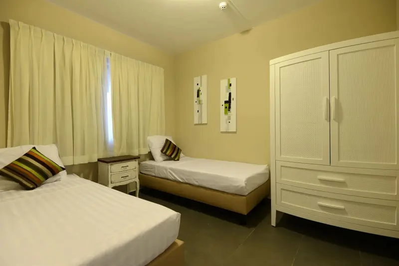 Une chambre lumineuse avec deux lits simples et une décoration sobre.