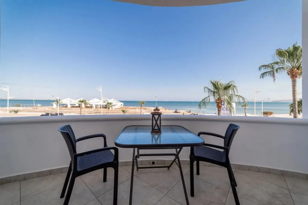 Terrasse avec table et chaises donnant sur la mer.