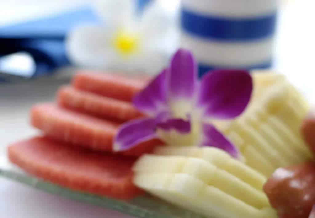 Assortiment de charcuterie et de fruits décorés d'une fleur.