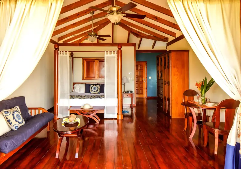 Une chambre spacieuse avec un lit à baldaquin et un coin repas.