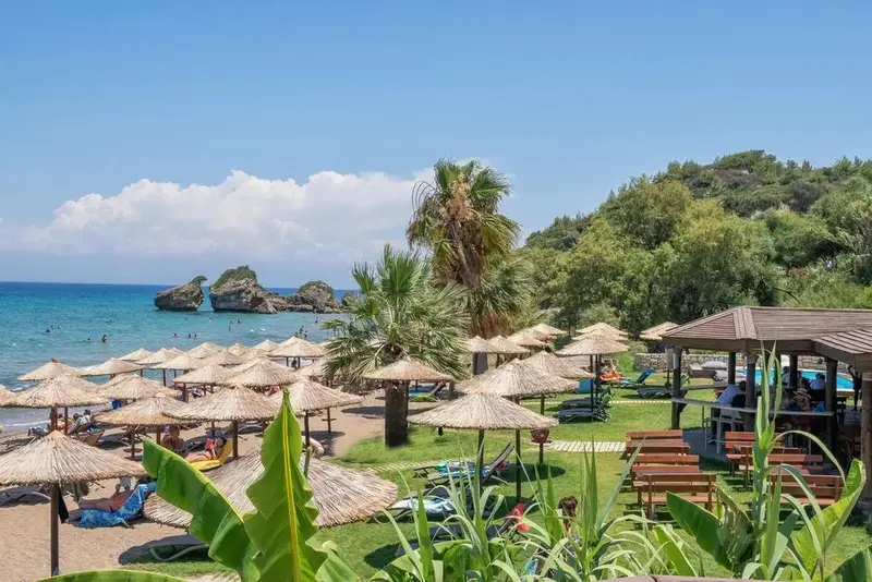Une plage ensoleillée avec des parasols en chaume et des transats.