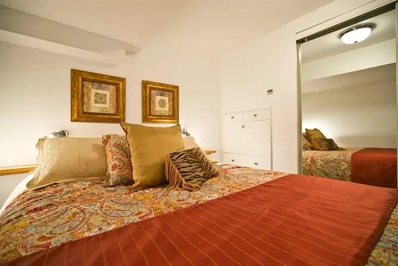 Un lit recouvert d'une courtepointe colorée et de coussins décoratifs dans une chambre.