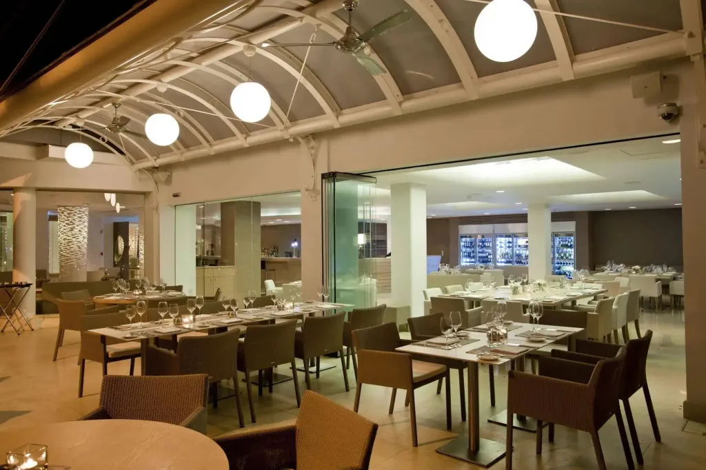 Une salle de restaurant lumineuse avec des tables dressées et des chaises confortables.
