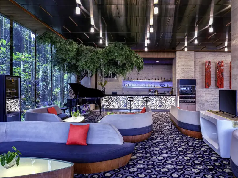 Un espace de détente intérieur avec des canapés incurvés et un bar au fond.