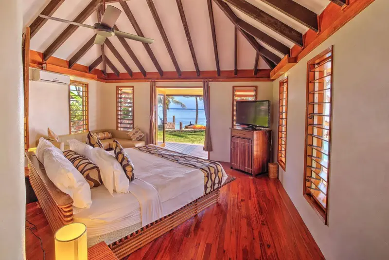 Une chambre lumineuse avec un lit king-size donnant sur une vue sur la mer.