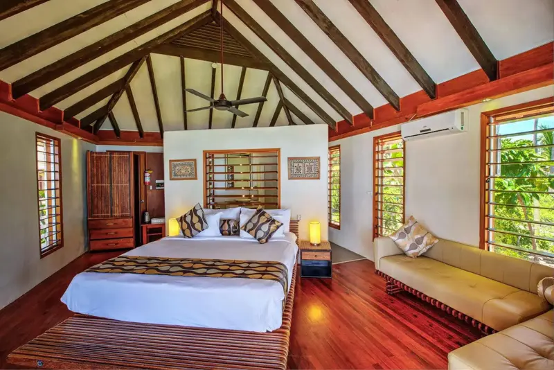 Une chambre lumineuse avec un lit double et un coin salon.