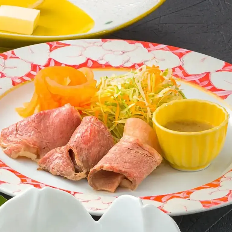 Assiette de viande froide accompagnée de crudités et d'une sauce.