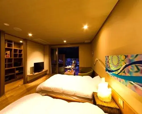 Une chambre lumineuse avec deux lits et un accès à un balcon.