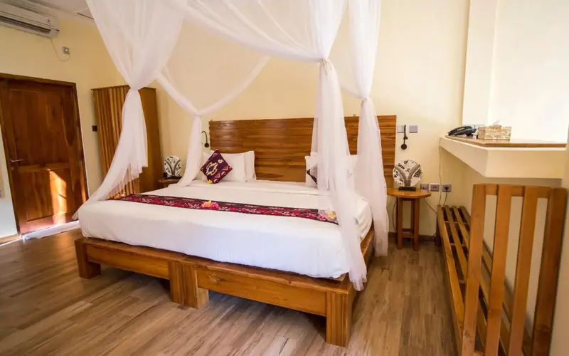 Une chambre lumineuse avec un grand lit à baldaquin en bois.