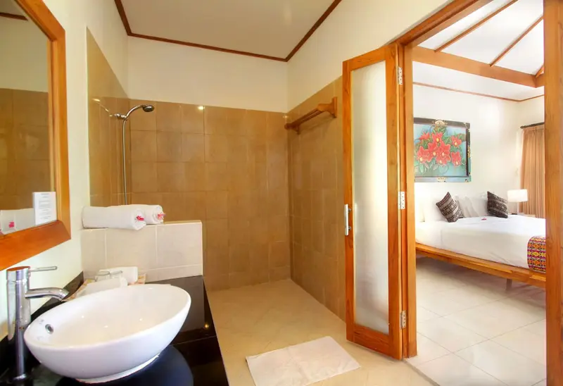 Une salle de bain lumineuse s'ouvre sur une chambre à coucher.