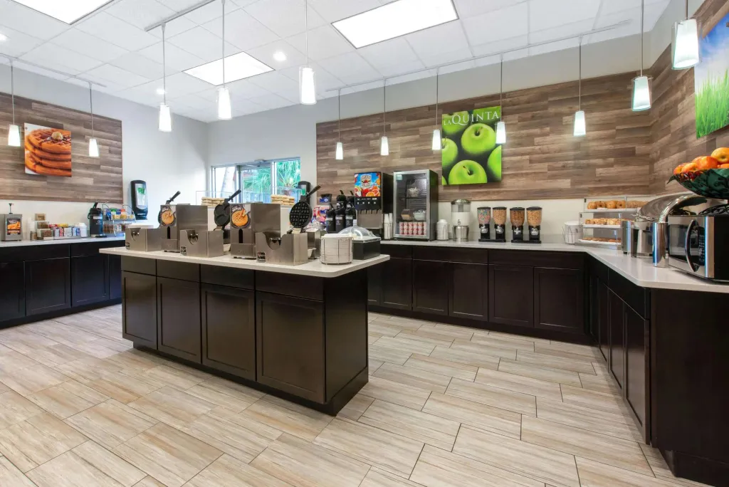 Un comptoir de buffet propose des boissons et des céréales dans une salle lumineuse.