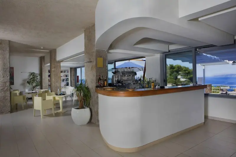 Un comptoir de bar moderne s'ouvre sur une vue sur la mer.