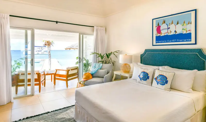 Une chambre lumineuse s'ouvre sur une terrasse avec vue sur la mer.