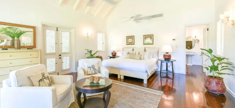 Une chambre lumineuse avec un grand lit et un coin salon.