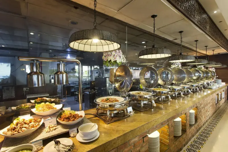 Un long buffet propose une variété de plats chauds et froids.