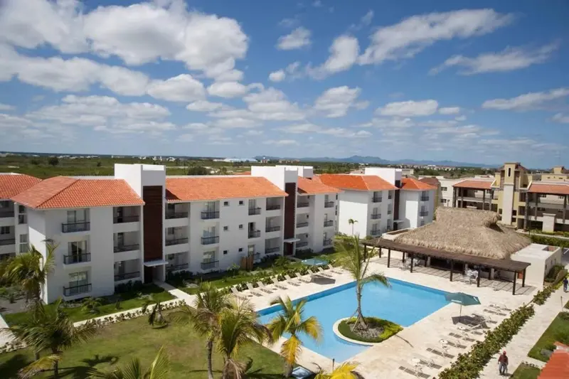 Vue aérienne d'un complexe hôtelier blanc avec piscine et végétation tropicale.