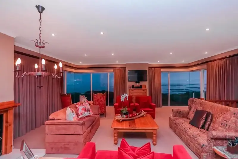 Un salon spacieux s'ouvre sur une vue nocturne de la mer.