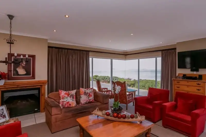Un salon chaleureux offre une vue dégagée sur la mer.