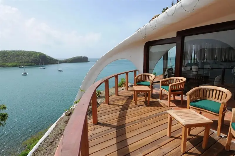 Terrasse en bois avec mobilier de jardin donnant sur une baie abritée.