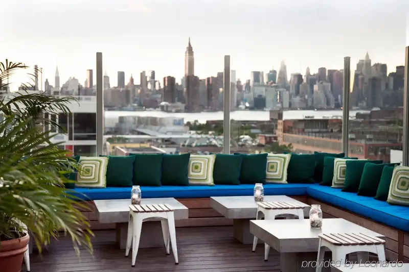 Espace de détente extérieur avec mobilier et vue sur la ville.