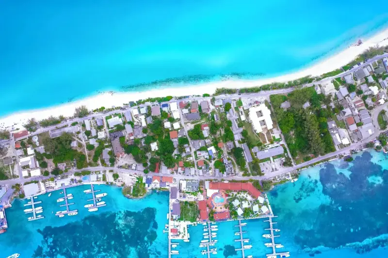 Vue aérienne d'une station balnéaire bordée de plages et de végétation luxuriante.