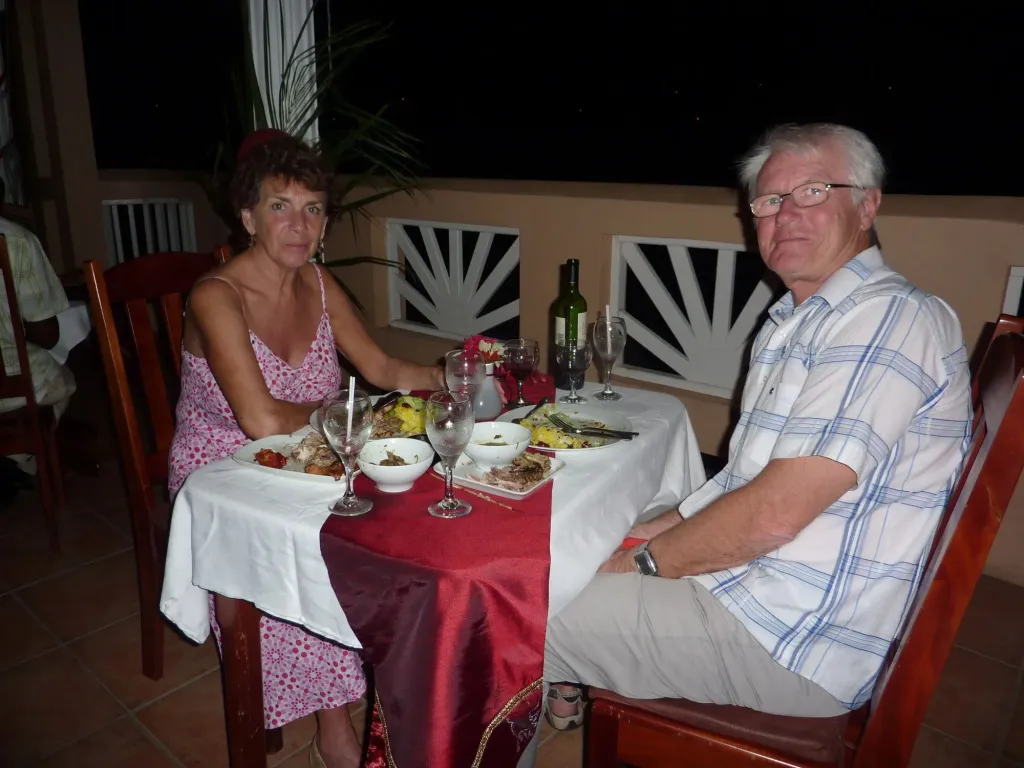 Un couple est assis à une table décorée pour un repas en extérieur.
