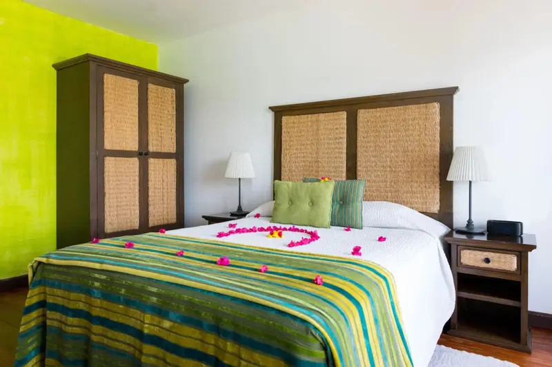 Une chambre lumineuse avec un grand lit décoré de fleurs.
