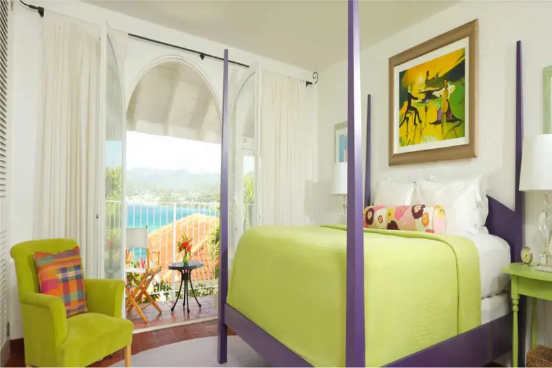 Une chambre lumineuse avec un lit à baldaquin donnant sur une vue sur la mer.