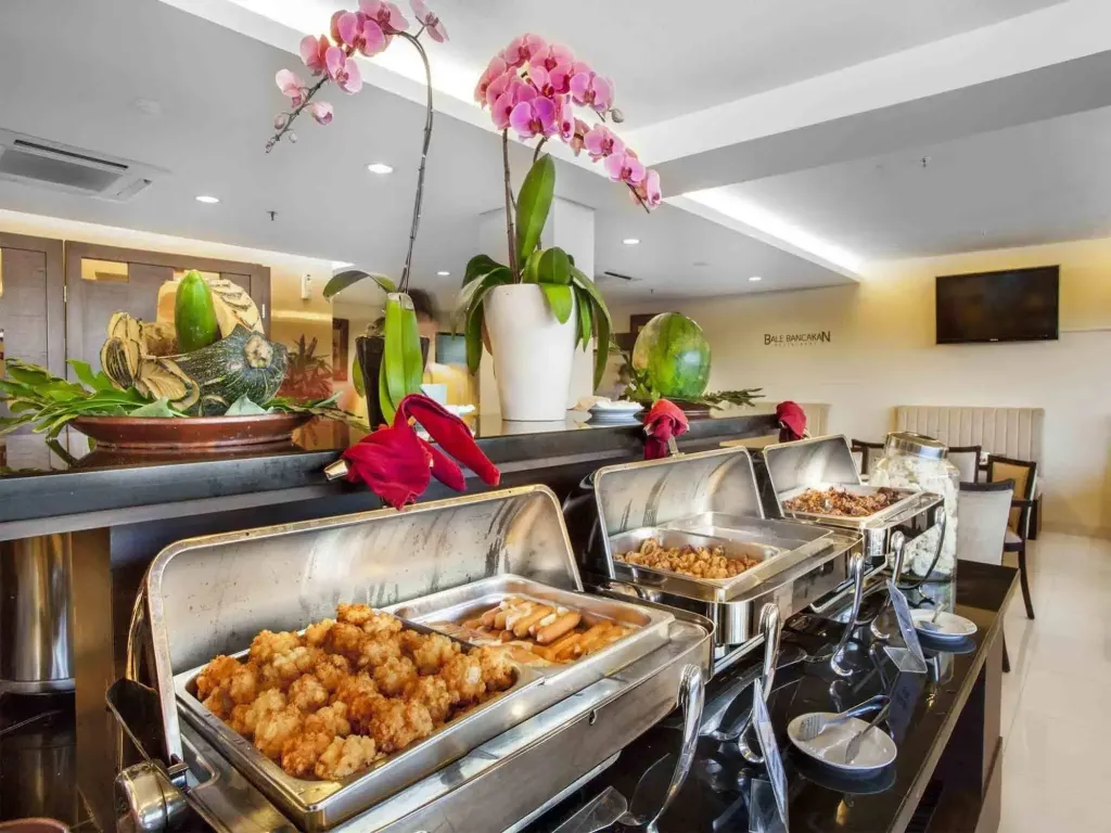 Un buffet propose une variété de plats et de fruits frais.
