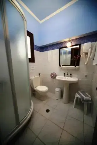 Une salle de bain claire avec douche, lavabo et toilettes.