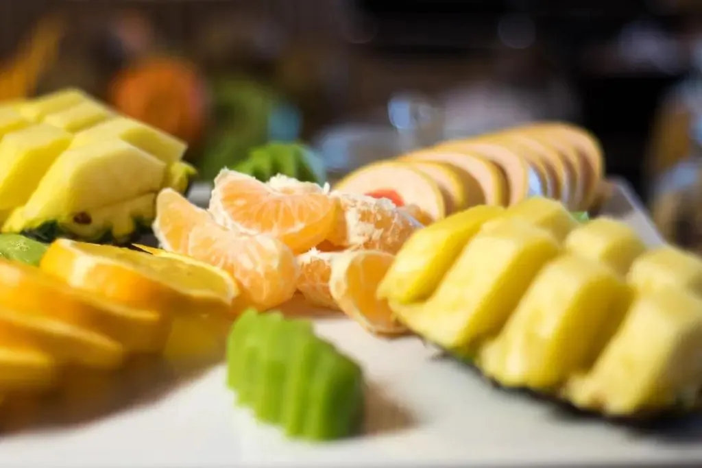 Assortiment de fruits frais coupés et disposés sur un plat blanc.