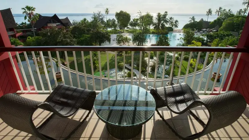 Terrasse avec mobilier d'extérieur donnant sur une piscine et la mer.