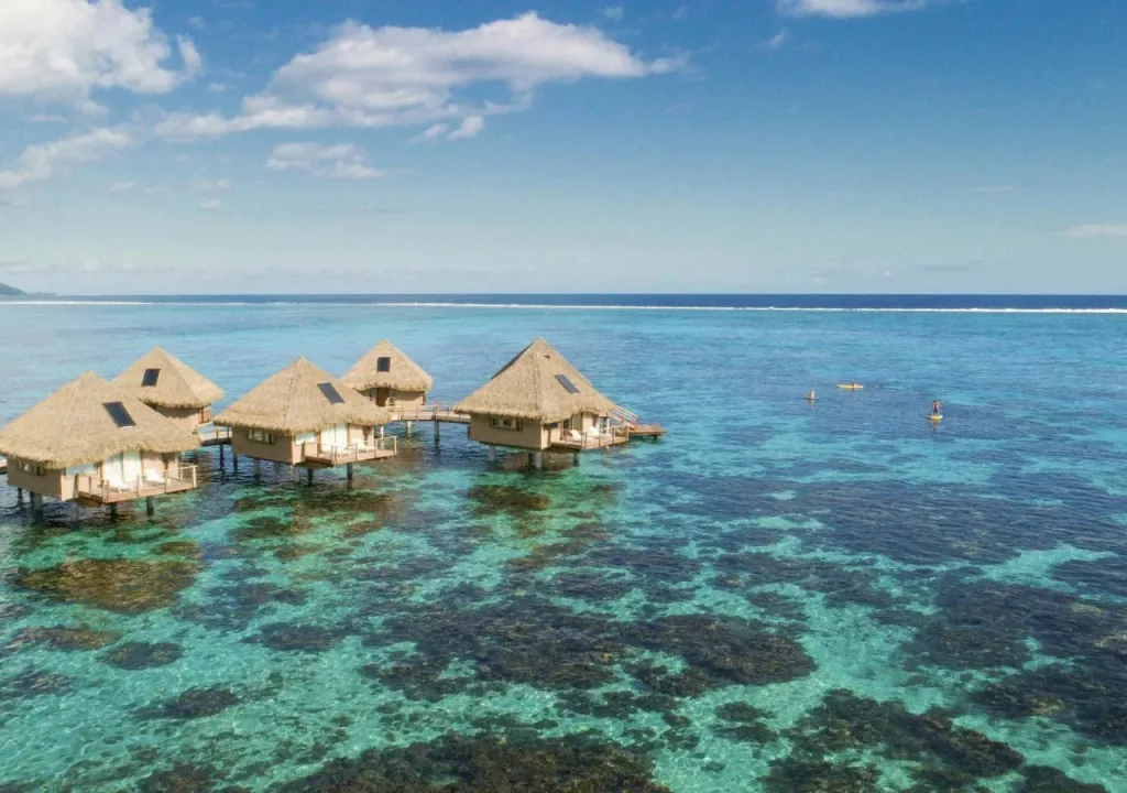 Des bungalows sur pilotis s'étendent sur une eau turquoise et peu profonde.