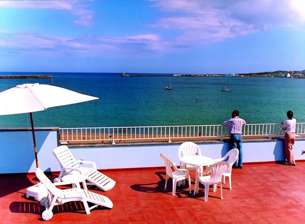 Terrasse avec transats et vue sur la mer.