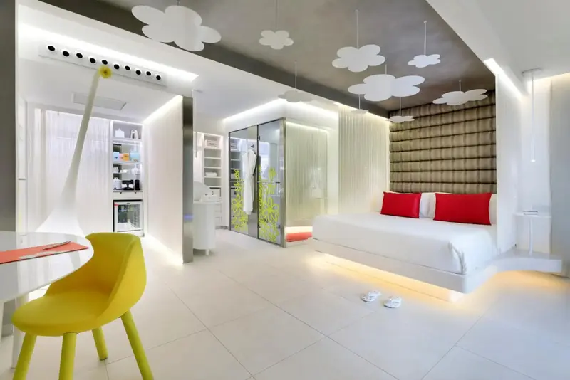 Une chambre lumineuse avec un lit moderne et un coin repas.