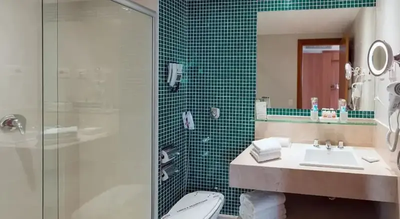 Une salle de bain lumineuse avec douche à l'italienne et vasque sur plan de travail.